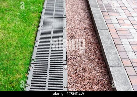 système de drainage dans le parc, grille de drainage et galets gros plan. Banque D'Images