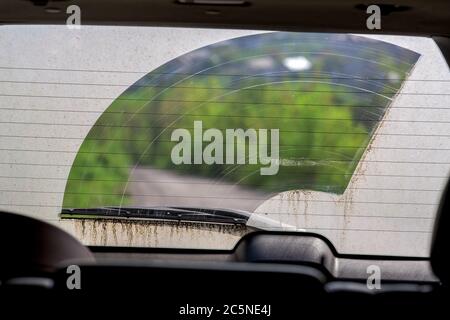 vitre arrière sale de la voiture dans la vue de la poussière de l'intérieur de la voiture à travers la vitre essuyée. Banque D'Images