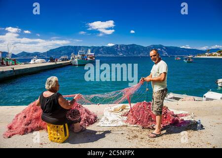 Agios Georgios Lichados Evia , Grèce -10 juin 2018: Aiguille avec fil dans le pêcheur et sa femme mains de réparer le filet pour la pêche à la ligne. Evia , Grèce. Banque D'Images