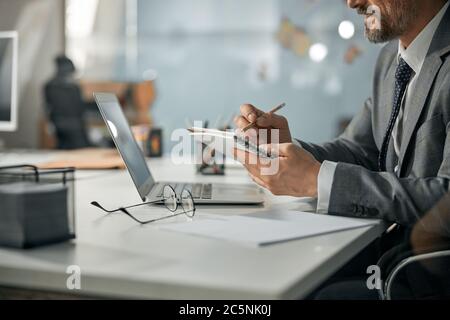 Main d'homme avec écriture au stylo sur le carnet Banque D'Images