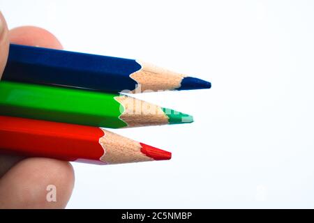 Une personne tenant trois crayons de couleur différente de crayon de bois dans sa main douce Banque D'Images