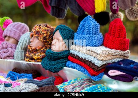 Comptoir avec chapeaux en laine tricotés et foulards colorés avec tête de mannequin. Banque D'Images