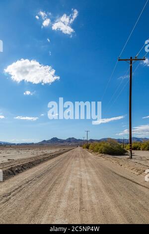 En regardant le long d'une longue route poussiéreuse non pavée dans la campagne de la Californie Banque D'Images