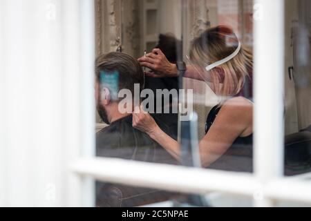 Rochester, Kent, Royaume-Uni. 4 juillet 2020. Un coiffeur tond les cheveux dans un coiffeur nouvellement ouvert. L'U.K rouvre des pubs, des restaurants, des coiffeurs, des coiffeurs et des hôtels le 4 juillet après avoir été fermé depuis mars en raison de l'épidémie de coronavirus. Crédit: Yousef Al Nasser/ Alamy Live News Banque D'Images