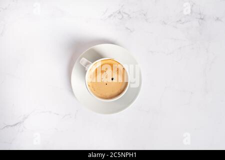 Tasse de café / cappuccino / expresso avec une soucoupe sur une table en marbre blanc Banque D'Images