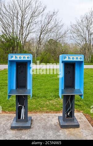 Deux anciens téléphones payants abandonnés dans un parking avec le téléphone retiré Banque D'Images