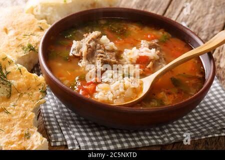 Soupe de Kharcho au bœuf, riz aux épices et légumes, servi avec du pain géorgien en gros plan sur la table. Horizontale Banque D'Images