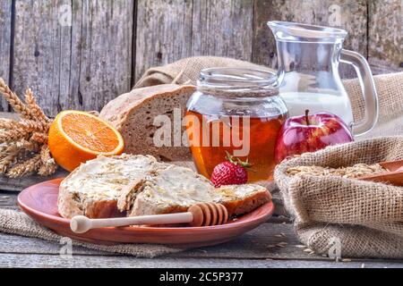 Petit déjeuner sain avec du miel, des fruits et du pain complet. Le concept de saine alimentation et de nutrition. Composition de style vintage. Banque D'Images