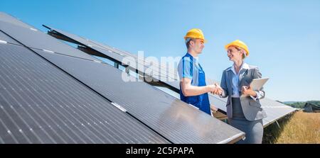 Travailleur de la construction et de l'investisseur en installation solaire shaking hands Banque D'Images