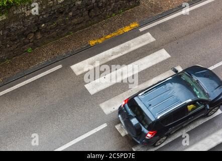 Voiture passant par les bandes de passage de zébra vu d'en haut Banque D'Images