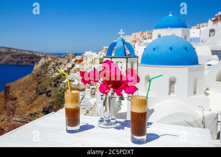 Boisson rafraîchissante et fleurs sur une table en bois sur fond de l'île de Santorin Banque D'Images