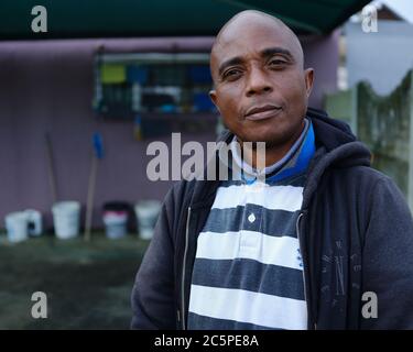 John Lusamba Mbombo, un propriétaire d'entreprise sud-africain à son lieu de travail. Il dirige une entreprise de lavage de voiture à succès au Cap, en Afrique du Sud. Banque D'Images