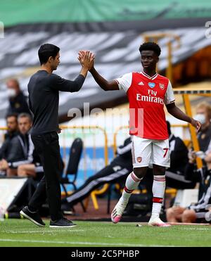 Mikel Arteta, le gérant de l'arsenal (à gauche), fait le bukayo Saka d'Arsenal après qu'il a été remplacé lors du match de la première ligue à Molineux, Wolverhampton. Banque D'Images