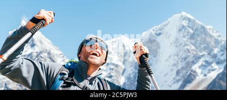 Portrait de l'homme de Hiker souriant sur Taboche 6495m et Cholatse 6440m pics fond avec des bâtons de trekking, UV protégeant des lunettes de soleil. Il appréciant la montagne Banque D'Images