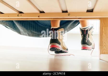 Nouvelles bottes de randonnée avec lacets dénoués sous la mauvaise vue dans la lumière du soleil matin nouveau jour. Nouvelle image de concept de début de journée active. Banque D'Images