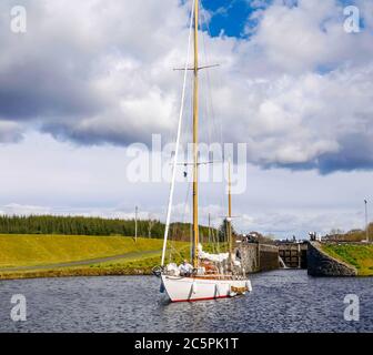 Yacht à voile traversant l'écluse sur le canal de Crinan, Argyll, Écosse, Royaume-Uni Banque D'Images