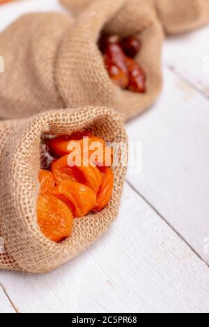 abricots séchés et dattes aux fruits dans des sacs en toile. Mise au point sélective, arrière-plan flou Banque D'Images