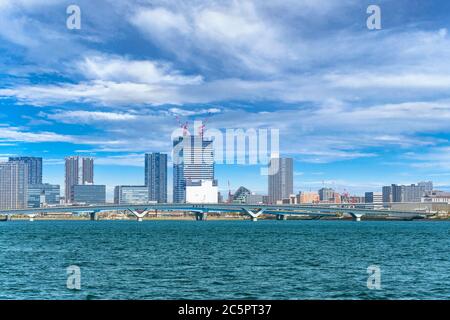 Vue sur la mer du pont Toyosu Ohashi sur le canal Harumi menant au marché de gros de poissons de Toyosu avec les gratte-ciels du quai urbain LaLaLaLaport dans le Th Banque D'Images