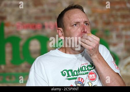 Joey Chestnut, un concurrent, établit un nouveau record du monde avec 75 hot dogs pour remporter la division masculine du célèbre concours international de hot dogs-manger annuel Nathan du 4 juillet dans le quartier de Brooklyn à New York, NY, le 4 juillet 2020. Cette année, la compétition s'est tenue à l'intérieur d'un bâtiment sans grand public, où les concurrents ont été séparés par des diviseurs de plexiglas en raison de préoccupations liées à la COVID-19, et pendant dix minutes, Chestnut a consommé 75 hot dogs, et Sodo en a consommé 48 et demi. (Anthony Behar/Sipa États-Unis) Banque D'Images