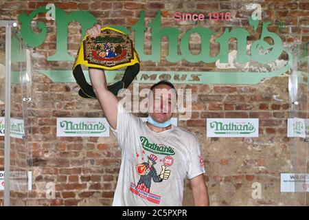 Joey Chestnut, un concurrent, célèbre après avoir enregistré un nouveau record du monde avec 75 hot dogs pour remporter la division masculine du célèbre concours international de hot dogs-manger annuel Nathan du 4 juillet dans le quartier de Brooklyn à New York, NY, le 4 juillet 2020. Cette année, la compétition s'est tenue à l'intérieur d'un bâtiment sans grand public, où les concurrents ont été séparés par des diviseurs de plexiglas en raison de préoccupations liées à la COVID-19, et pendant dix minutes, Chestnut a consommé 75 hot dogs, et Sodo en a consommé 48 et demi. (Anthony Behar/Sipa États-Unis) Banque D'Images