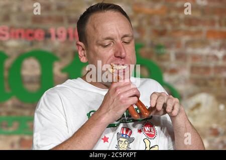 Joey Chestnut, un concurrent, établit un nouveau record du monde avec 75 hot dogs pour remporter la division masculine du célèbre concours international de hot dogs-manger annuel Nathan du 4 juillet dans le quartier de Brooklyn à New York, NY, le 4 juillet 2020. Cette année, la compétition s'est tenue à l'intérieur d'un bâtiment sans grand public, où les concurrents ont été séparés par des diviseurs de plexiglas en raison de préoccupations liées à la COVID-19, et pendant dix minutes, Chestnut a consommé 75 hot dogs, et Sodo en a consommé 48 et demi. (Anthony Behar/Sipa États-Unis) Banque D'Images