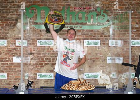 Joey Chestnut, un concurrent, célèbre après avoir enregistré un nouveau record du monde avec 75 hot dogs pour remporter la division masculine du célèbre concours international de hot dogs-manger annuel Nathan du 4 juillet dans le quartier de Brooklyn à New York, NY, le 4 juillet 2020. Cette année, la compétition s'est tenue à l'intérieur d'un bâtiment sans grand public, où les concurrents ont été séparés par des diviseurs de plexiglas en raison de préoccupations liées à la COVID-19, et pendant dix minutes, Chestnut a consommé 75 hot dogs, et Sodo en a consommé 48 et demi. (Anthony Behar/Sipa États-Unis) Banque D'Images