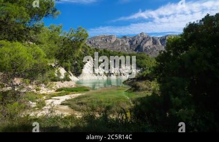 Lac de réserevoir de barrage de couleur turquoise entouré de forêts vertes et de montagnes rocheuses à Guadalest, Costa Blanca, Espagne Banque D'Images