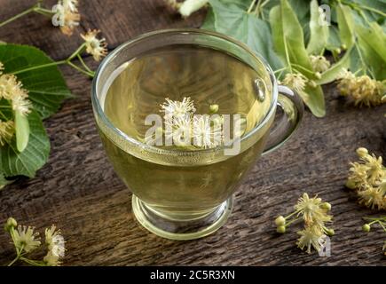 Linden de thé de fleur dans une tasse transparente sur une table Banque D'Images