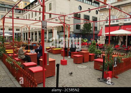 Londres, Royaume-Uni - 4 juillet 2020 : les gens apprécient leur repas à emporter en plein air à covent Garden. La vie quotidienne à Londres un samedi avant l'ouverture des pubs le 4 juillet, selon les nouveaux conseils du gouvernement. Les pubs ont été avidé de mettre en place des mesures sociales de distancement dans le cadre de la nouvelle normale contre l'épidémie de covid19 Banque D'Images