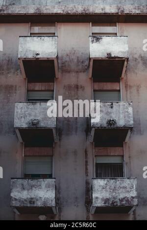 Vue verticale avec une façade d'un immeuble résidentiel: Six balcons avec fenêtres simples sur chacun, certains d'entre eux avec des stores partiellement fermés un mur grundy Banque D'Images