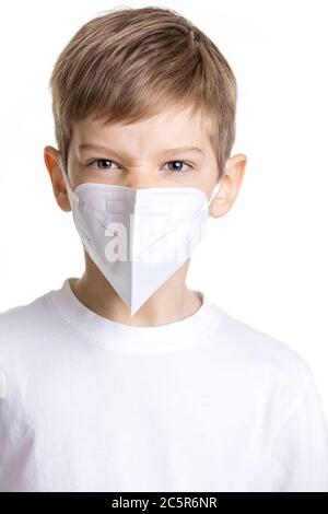 Portrait d'un jeune garçon dans un masque médical faisant face en colère sur fond blanc Banque D'Images