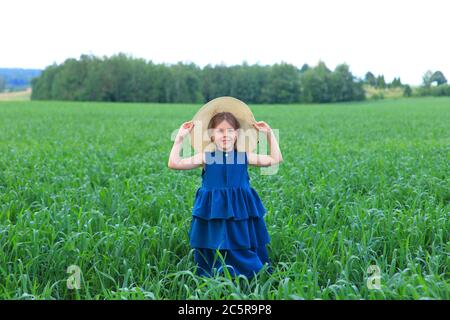 Belle petite fille court dans le champ d'été Banque D'Images