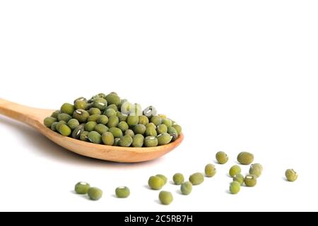 Une cuillère pleine de haricots mung crus – une graine de mung sur une cuillère en bois – isolée sur un fond blanc avec un éclairage studio Banque D'Images