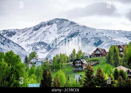 Crested Butte, États-Unis Colorado village en été avec des nuages et brouillard brumeux matin et des maisons sur la colline avec des arbres verts Banque D'Images