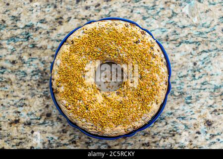 Dessert à la crème à la vanille jaune entier gâteau maison avec glaçage et pollen d'abeille décoration saine sur comptoir en granit plat au-dessus de la vue Banque D'Images