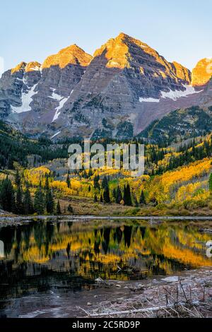 Le lac Maroon Bells au lever du soleil à Aspen, Colorado avec pic rocheux et neige en octobre 2019 automne et arbres vibrants reflet sur l'eau de la vertica Banque D'Images
