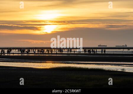 Des gens bondés jouant l'eau dans les zones humides de Gaomei pendant l'heure du coucher du soleil. District de Qingshui, Taichung City, Taïwan Banque D'Images