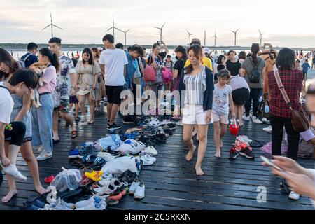 Des gens bondés jouant l'eau dans les zones humides de Gaomei pendant l'heure du coucher du soleil. District de Qingshui, Taichung City, Taïwan Banque D'Images