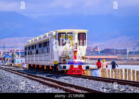 La voie de train de marchandises passe par le lac de sel de Chaka, province de Qinghai, Chine. Banque D'Images