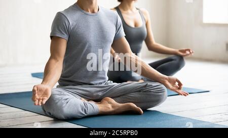 Jeune homme sportif fort méconnaissable assis en position lotus. Banque D'Images