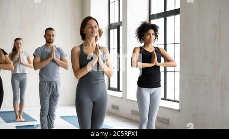Souriant, les gens de race mixte se tenant debout avec un geste de nom. Banque D'Images