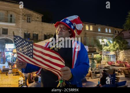 Un israélien habillé d'une tenue particulièrement patriotique Uncle Sam porte le drapeau américain lors de la célébration du jour de l'indépendance des États-Unis le 4 juillet à Jérusalem Israël Banque D'Images