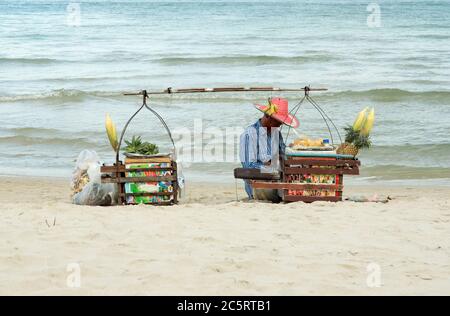 KOH SAMUI, THAÏLANDE - JUILLET 25 : un homme thaïlandais vend des fruits et du maïs sucré aux touristes sur la plage de Chaweng le 25 juillet 2013 à Koh Samui, Thaïlande. Commerce de busine Banque D'Images