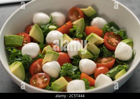 Salade avec avocat, tomates et mozzarella en gros plan Banque D'Images