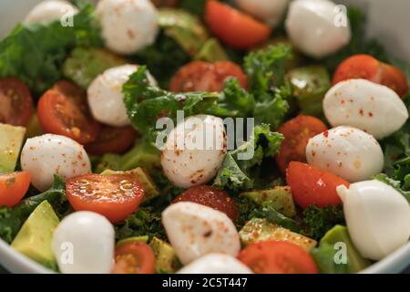 Salade avec avocat, tomates et mozzarella en gros plan Banque D'Images