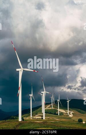 D'énormes éoliennes sur la colline à côté de l'immeuble. Banque D'Images