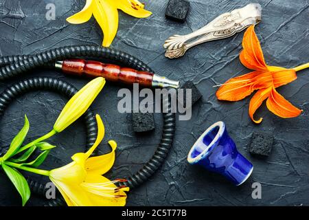 Narguilé asiatique fumant avec tabac à fleurs parfumé. Chicha au goût de Lily Banque D'Images