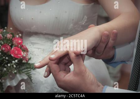 Jeunes mariés et bagues de remplacement de marié pendant le mariage. Banque D'Images