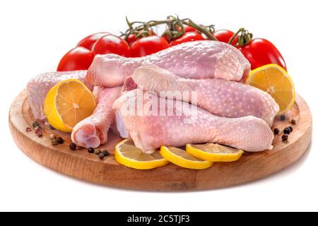 Des cuisses de poulet fraîches avec des tomates, du citron et des épices, sur fond blanc Banque D'Images