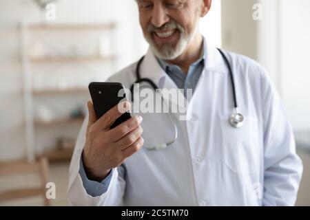 Gros plan sur le sourire d'un médecin de sexe masculin utilisent un smartphone Banque D'Images